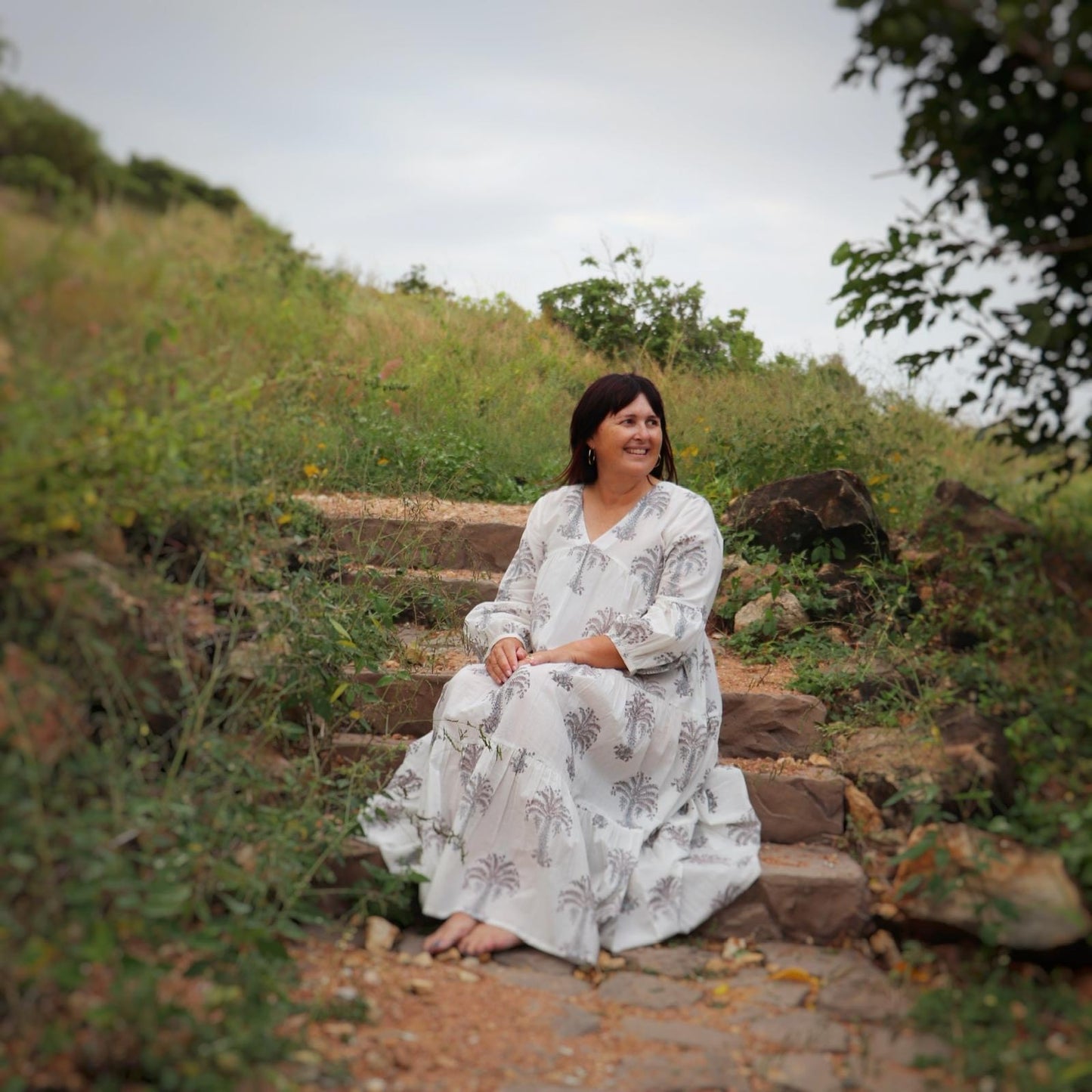 Woman wearing white maxi dress with grey palm block print