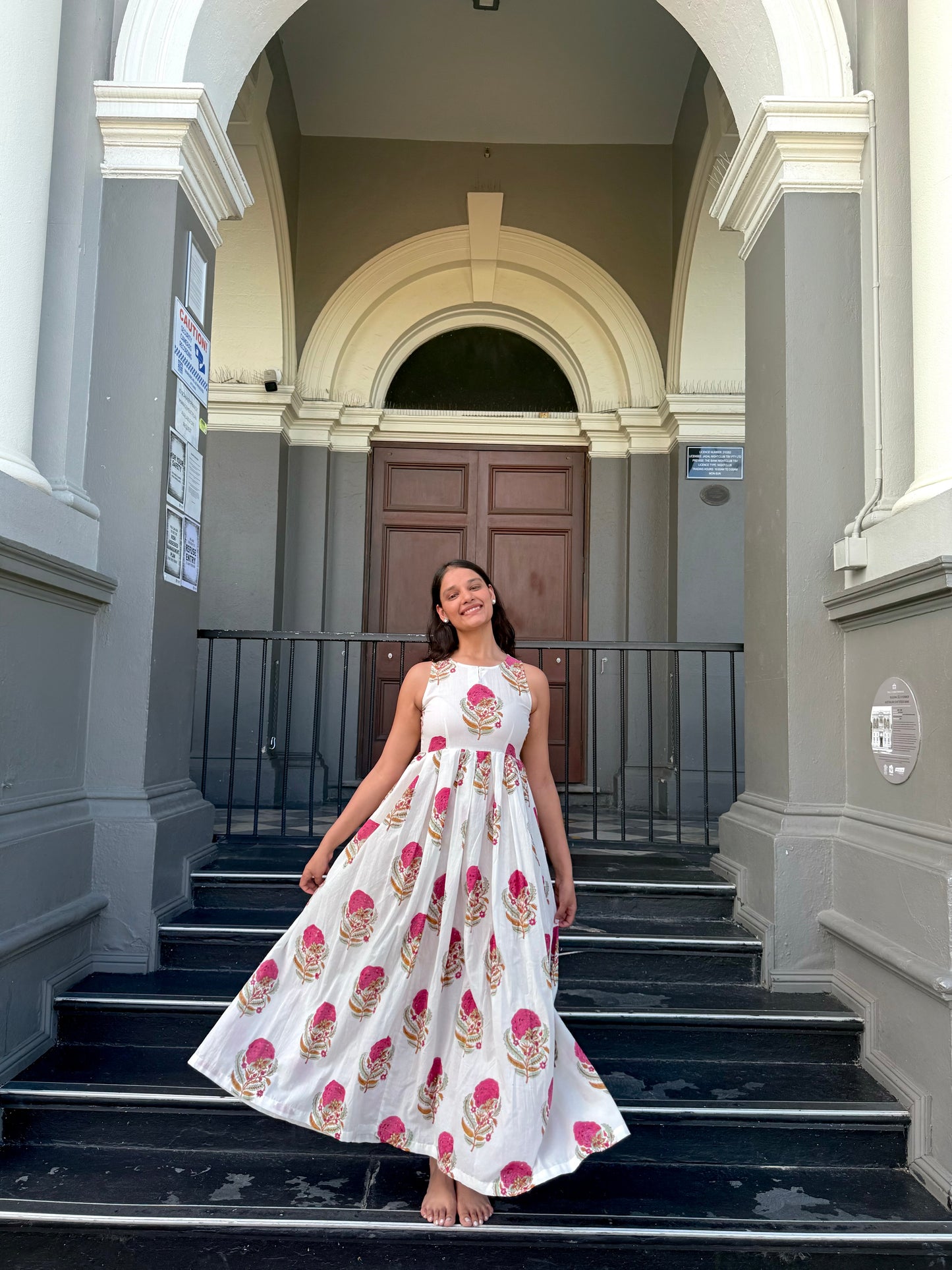Woman wearing pink floral maxi dress with halter neck
