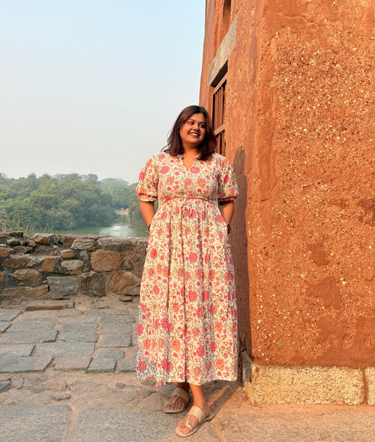 Woman wearing pink floral maxi dress with green block print details