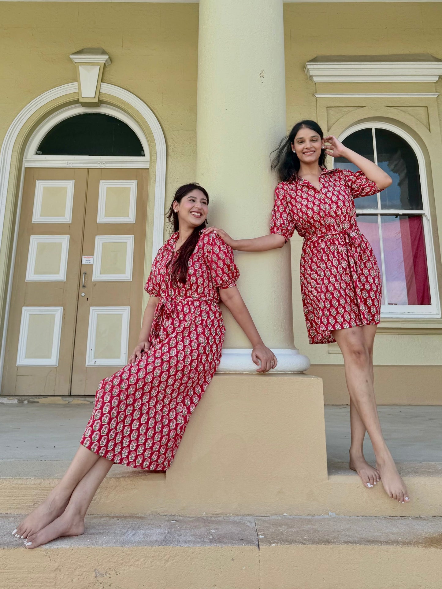 Close-up of button front detail on red cotton midi dress and crimson hour short dress