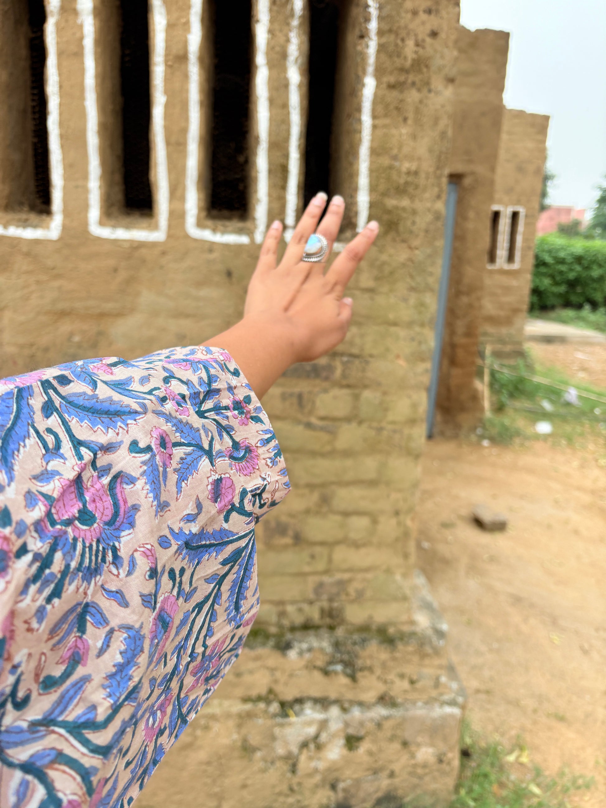 Woman wearing multi-color floral maxi dress with tiered design