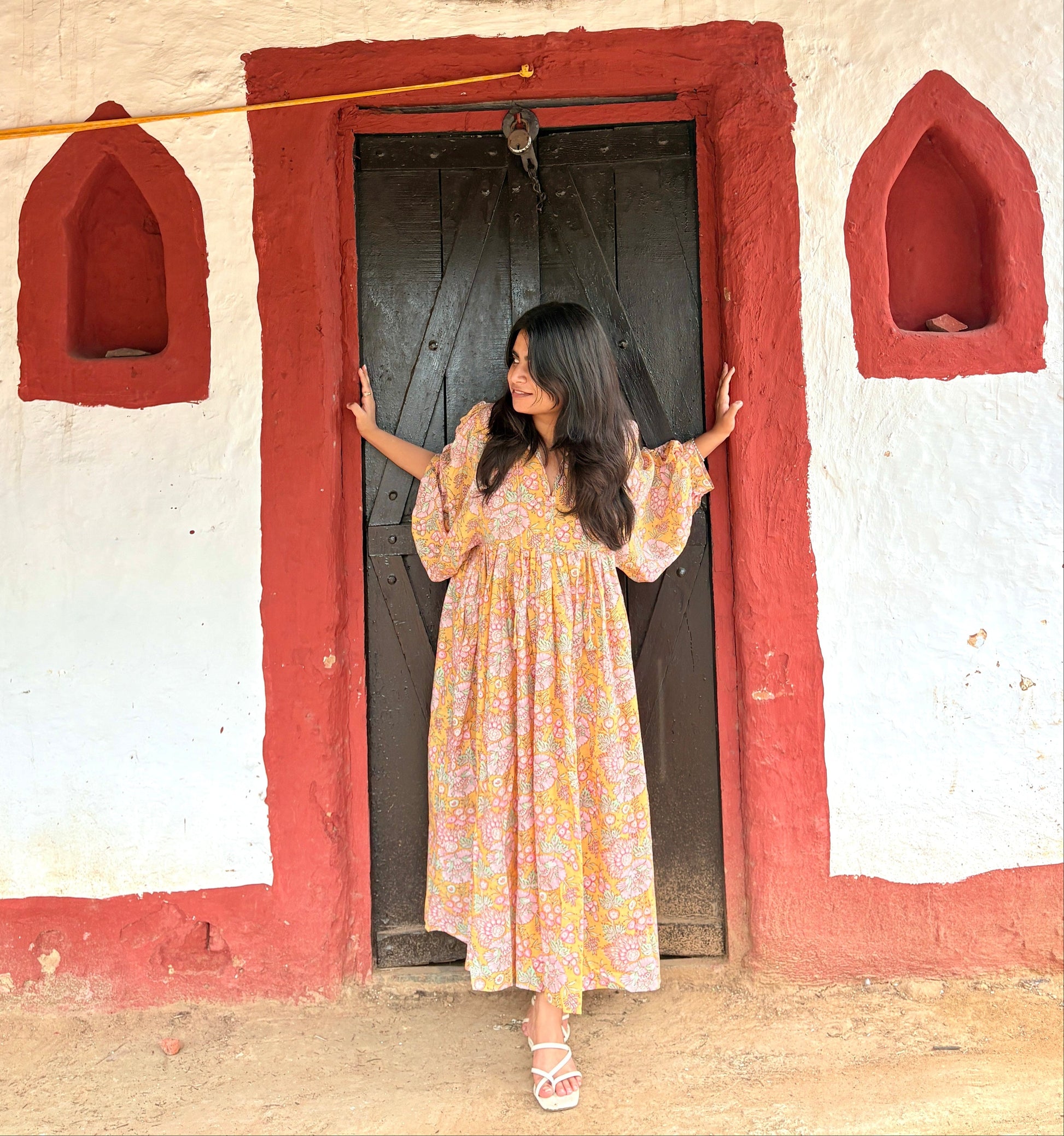 Woman wearing yellow maxi dress with green and pink floral screen print