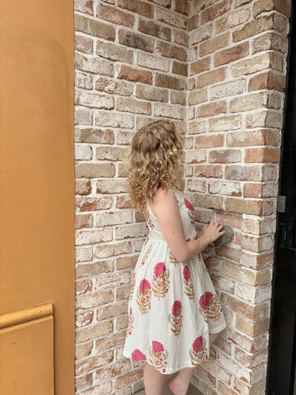 Detail of sleeveless halter design and playful floral pattern