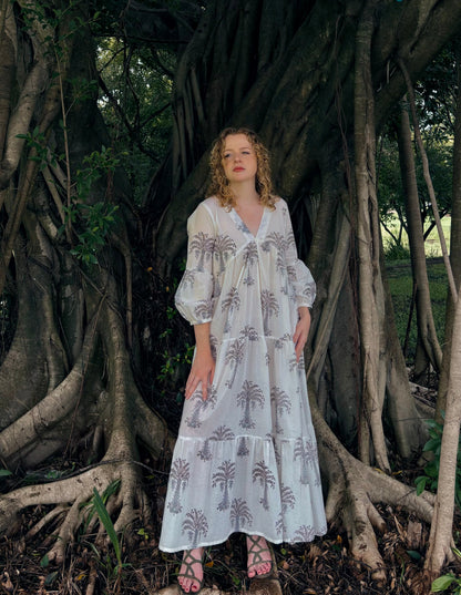 Woman wearing white maxi dress with grey palm block print