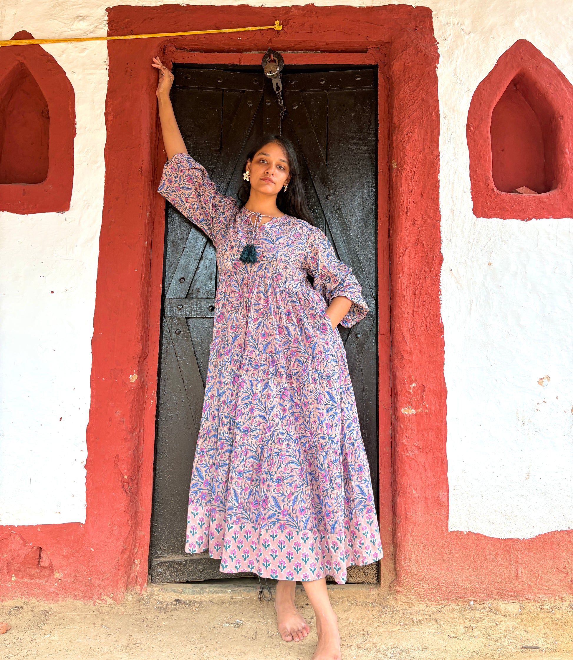 Woman wearing multi-color floral maxi dress with tiered design