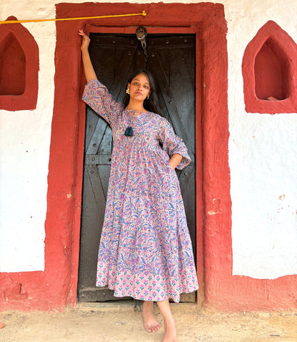 Woman wearing multi-color floral maxi dress with tiered design
