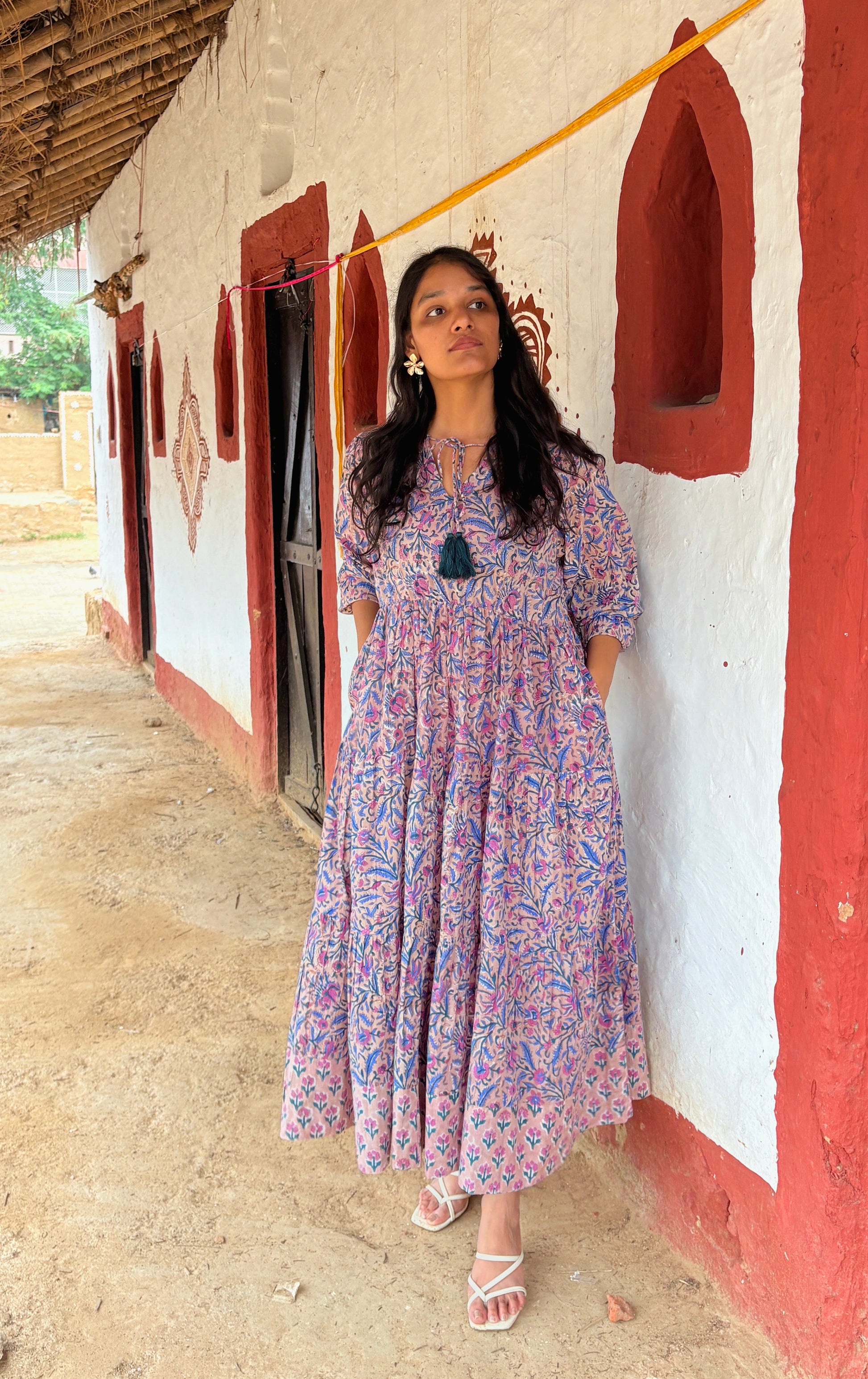 Woman wearing multi-color floral maxi dress with tiered design