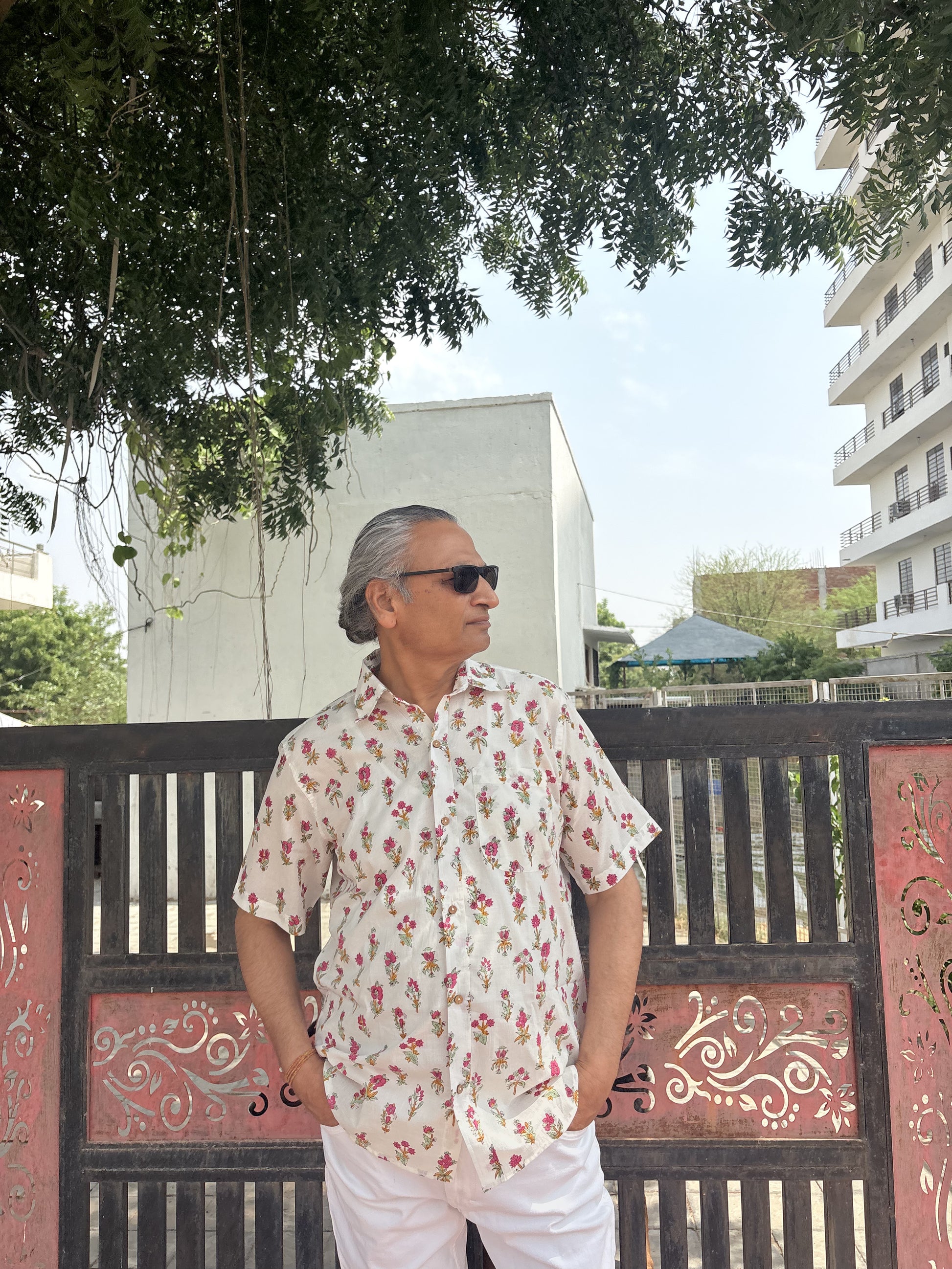Person wearing white shirt with pink floral block print