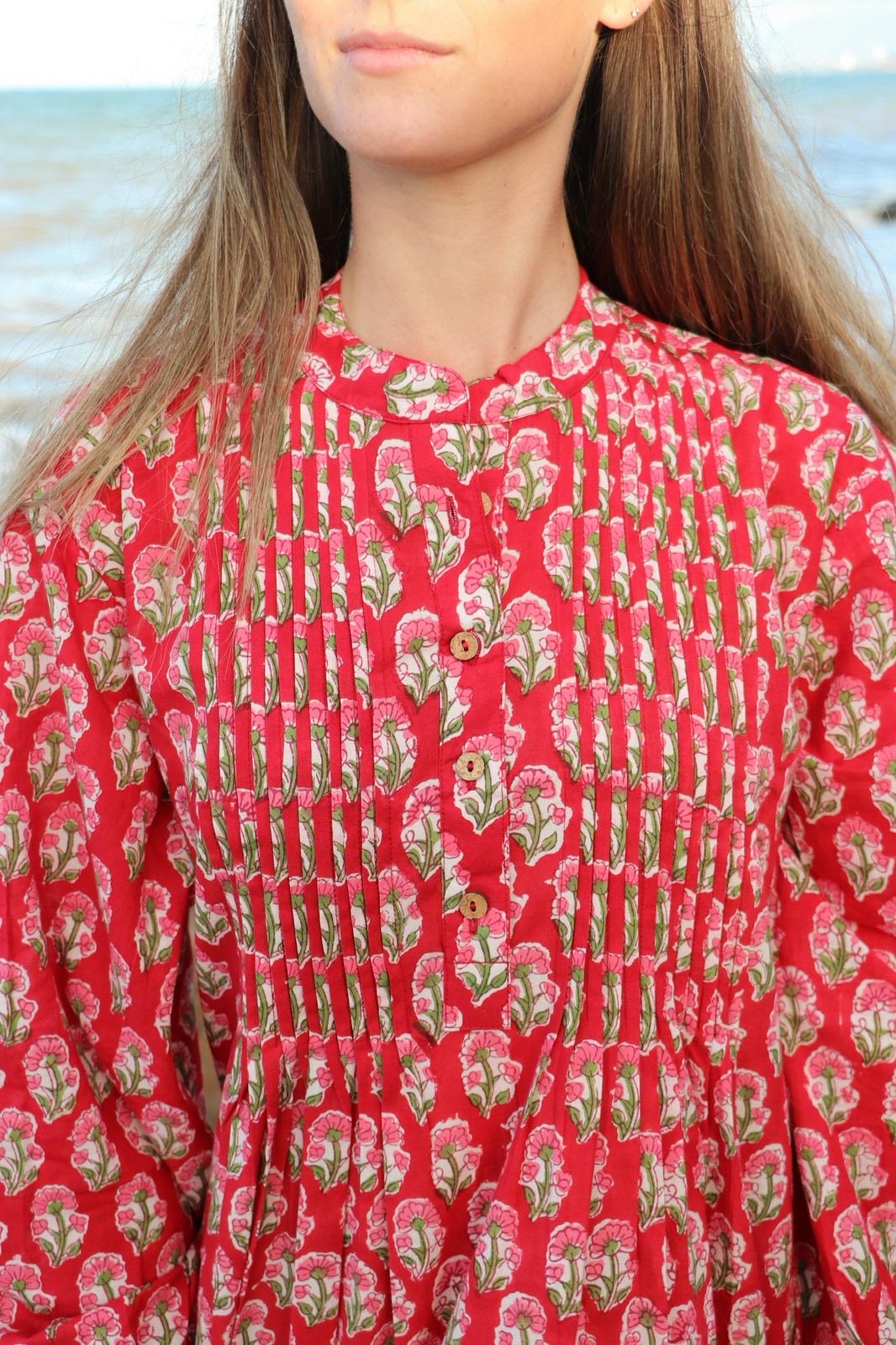 Close-up of pin-tuck detailing on red cotton maxi dress