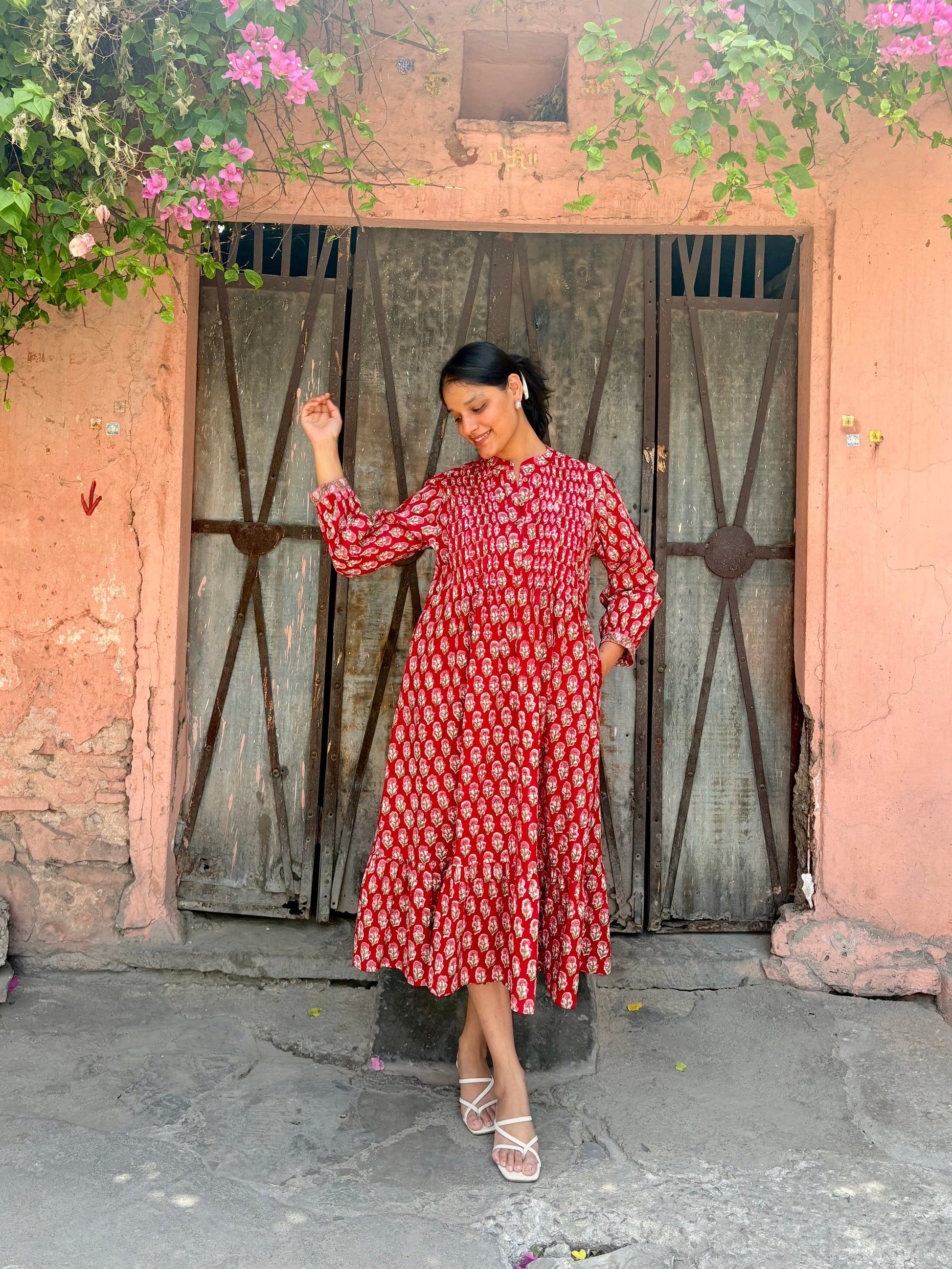 Detail of hidden pockets and flared hem on red maxi dress